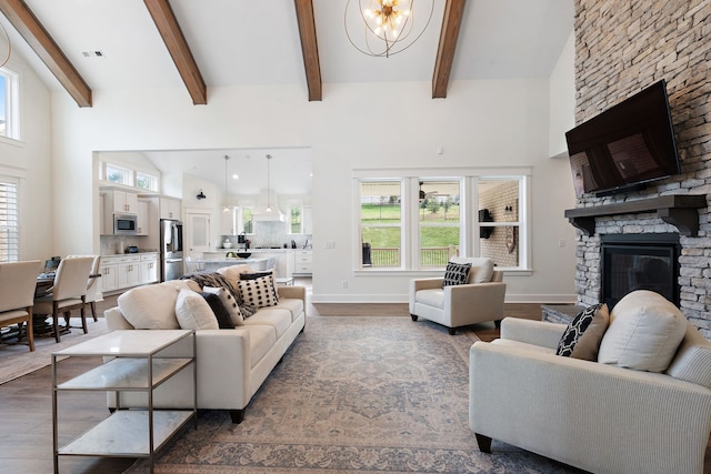 living room with a fireplace, a high ceiling, beamed ceiling, and wood-type flooring