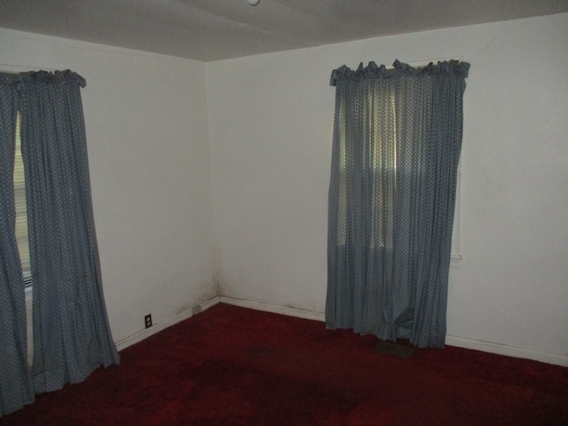 empty room featuring dark colored carpet