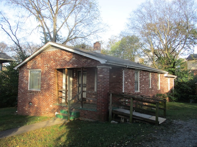 view of front facade featuring a front yard and a wooden deck