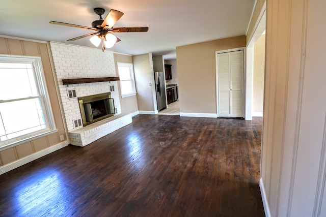 unfurnished living room with dark hardwood / wood-style floors, ceiling fan, and a fireplace