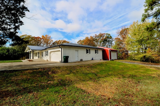 view of side of property with a garage and a lawn