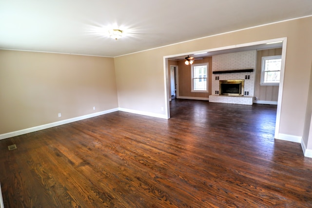 unfurnished living room featuring dark wood-type flooring, a fireplace, and ceiling fan