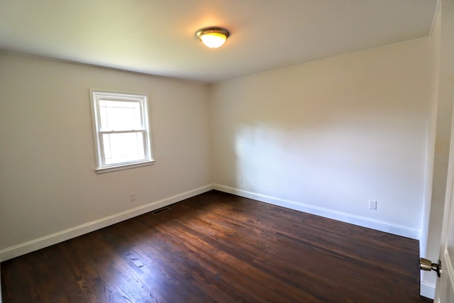 unfurnished room with dark wood-type flooring