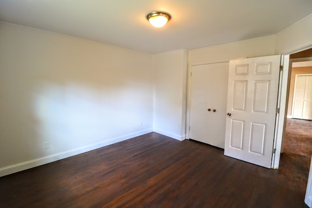 unfurnished room with dark wood-type flooring