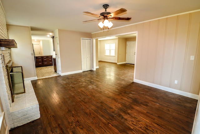 unfurnished living room with hardwood / wood-style floors, a fireplace, ornamental molding, and ceiling fan