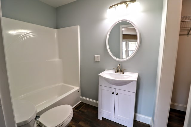 full bathroom featuring washtub / shower combination, wood-type flooring, toilet, and vanity