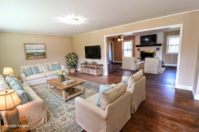 living room with ceiling fan, plenty of natural light, dark hardwood / wood-style floors, and a brick fireplace