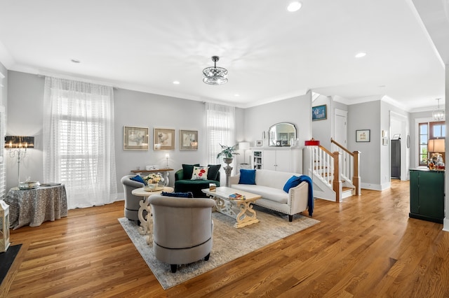 living room featuring a chandelier, plenty of natural light, light hardwood / wood-style floors, and crown molding