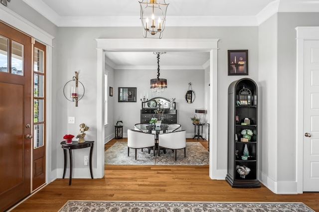 interior space featuring hardwood / wood-style floors, a notable chandelier, and ornamental molding