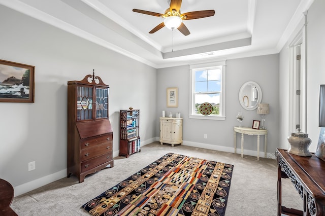 interior space with light colored carpet, ceiling fan, crown molding, and a tray ceiling