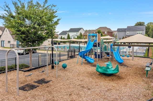 view of jungle gym with a fenced in pool