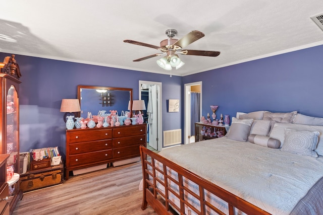 bedroom with light hardwood / wood-style flooring, ceiling fan, and ornamental molding