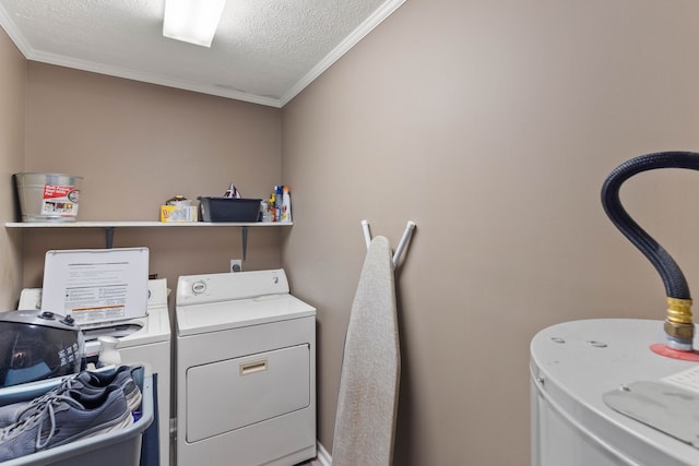 washroom with a textured ceiling, washer and clothes dryer, and ornamental molding