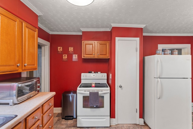 kitchen featuring a textured ceiling, white appliances, and ornamental molding