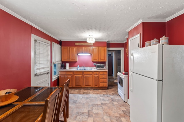 kitchen featuring a textured ceiling, white appliances, crown molding, and sink