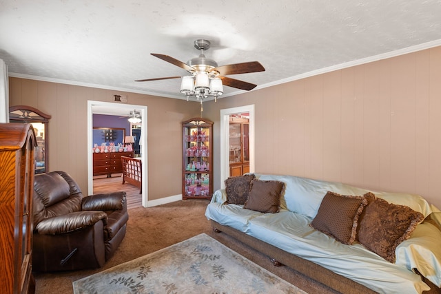 carpeted living room with crown molding, wooden walls, ceiling fan, and a textured ceiling