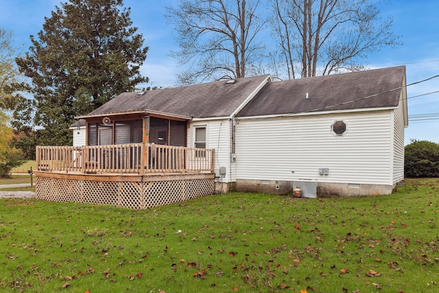 back of property with a sunroom, a deck, and a lawn