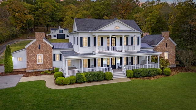 greek revival inspired property featuring a front yard and a porch