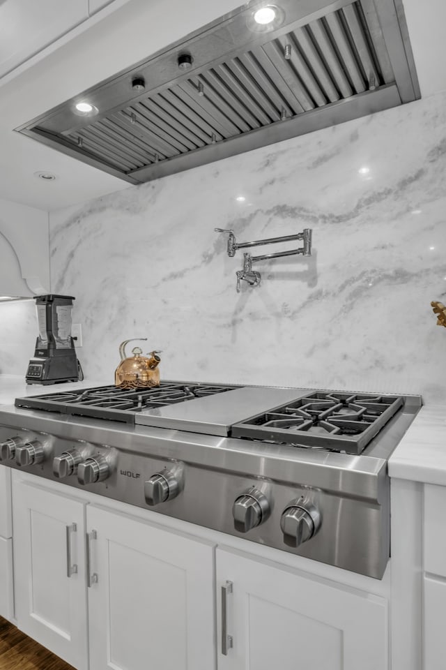 kitchen featuring white cabinets, stainless steel gas cooktop, tasteful backsplash, dark hardwood / wood-style floors, and ventilation hood