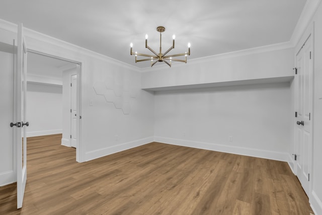 unfurnished dining area with wood-type flooring, a notable chandelier, and crown molding