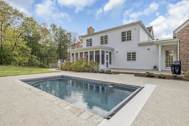 back of house with a sunroom and a patio area