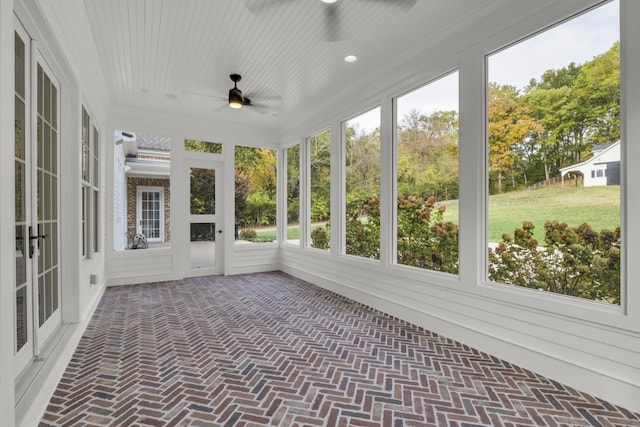 unfurnished sunroom with ceiling fan