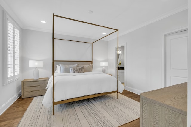 bedroom with hardwood / wood-style flooring, multiple windows, and crown molding