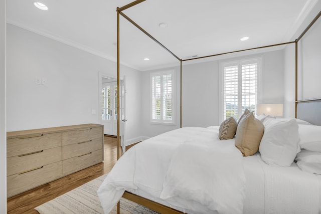 bedroom with ornamental molding and hardwood / wood-style floors