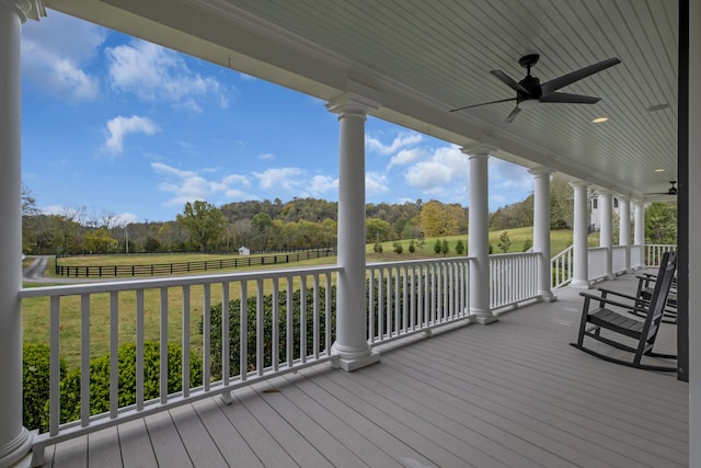 wooden deck with covered porch, a yard, a rural view, and ceiling fan