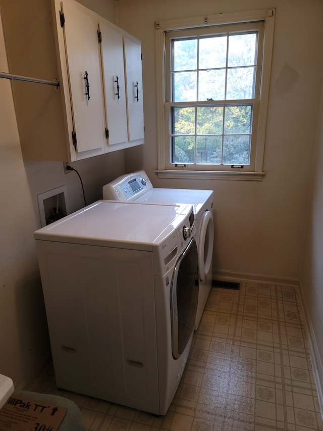 washroom with cabinets and washing machine and clothes dryer