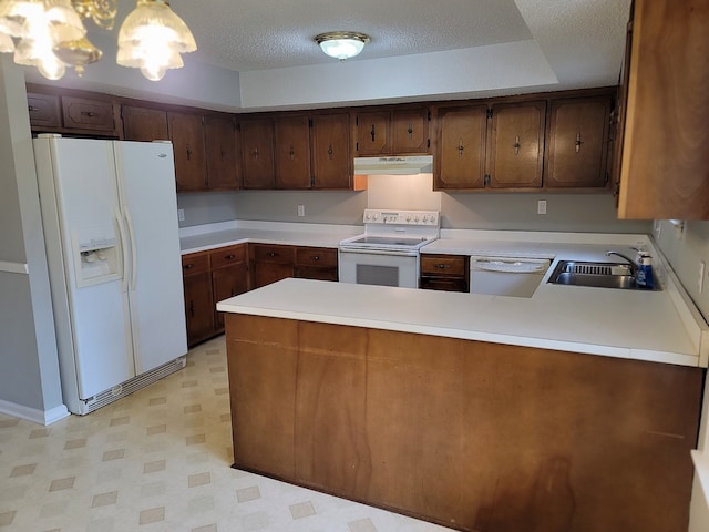 kitchen with sink, kitchen peninsula, a textured ceiling, white appliances, and a raised ceiling