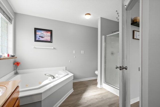 full bathroom featuring hardwood / wood-style flooring, a textured ceiling, independent shower and bath, vanity, and toilet