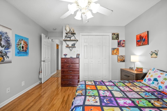 bedroom featuring ceiling fan, a textured ceiling, a closet, and light wood-type flooring