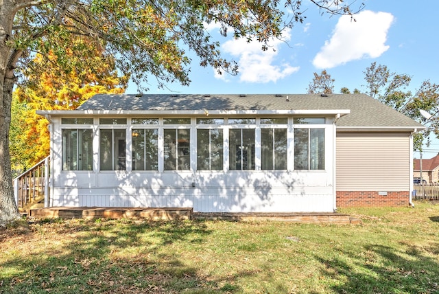 view of home's exterior with a sunroom and a yard