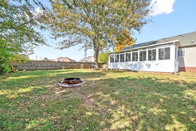 view of yard featuring a sunroom and an outdoor fire pit