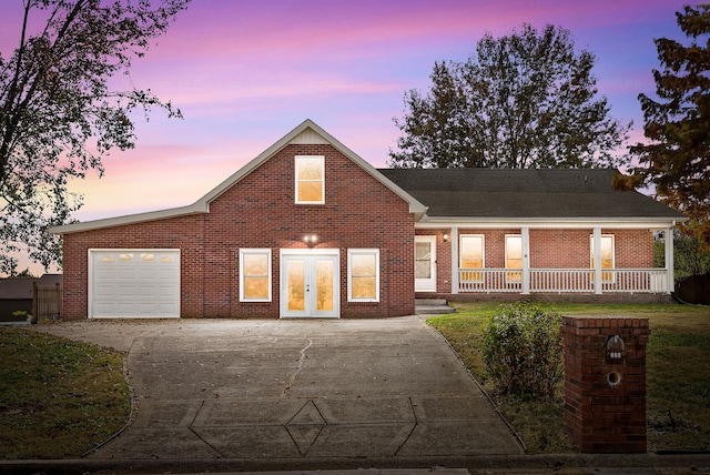 view of front facade with a lawn, a garage, and a porch