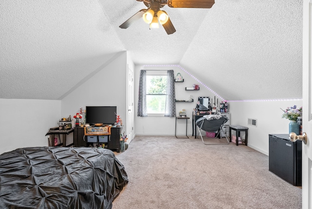 bedroom featuring carpet flooring, a textured ceiling, ceiling fan, and vaulted ceiling