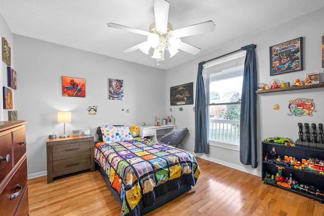 bedroom featuring light hardwood / wood-style floors, a textured ceiling, and ceiling fan