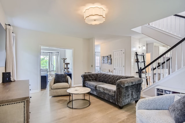 living room with a barn door and light hardwood / wood-style flooring