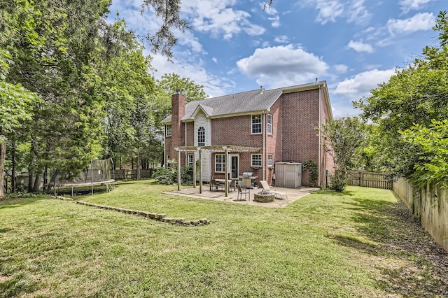 rear view of house featuring a patio, a yard, and a trampoline