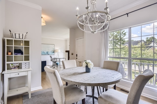 dining room featuring a healthy amount of sunlight, light hardwood / wood-style flooring, and crown molding