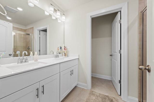 bathroom with vanity, a shower with shower door, and tile patterned floors