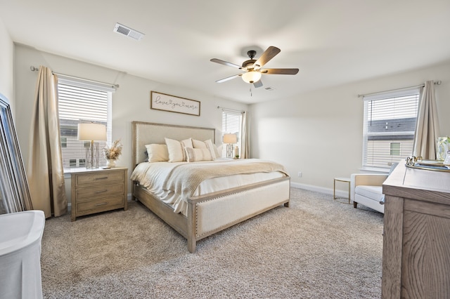 bedroom with multiple windows, light colored carpet, and ceiling fan