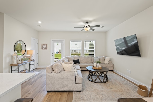 living room featuring ceiling fan and light hardwood / wood-style flooring