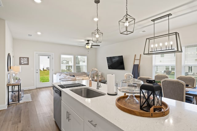 kitchen featuring light stone counters, dark hardwood / wood-style floors, pendant lighting, sink, and white cabinets