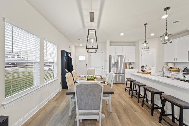 dining space with sink and light hardwood / wood-style flooring