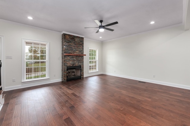 unfurnished living room featuring crown molding, dark wood-type flooring, ceiling fan, and a fireplace