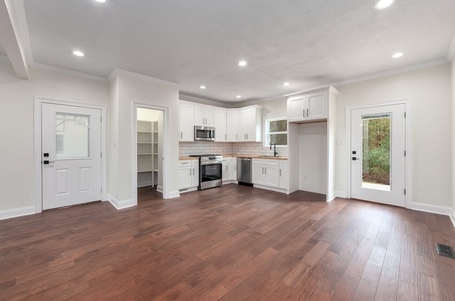 kitchen with white cabinetry, stainless steel appliances, sink, and backsplash