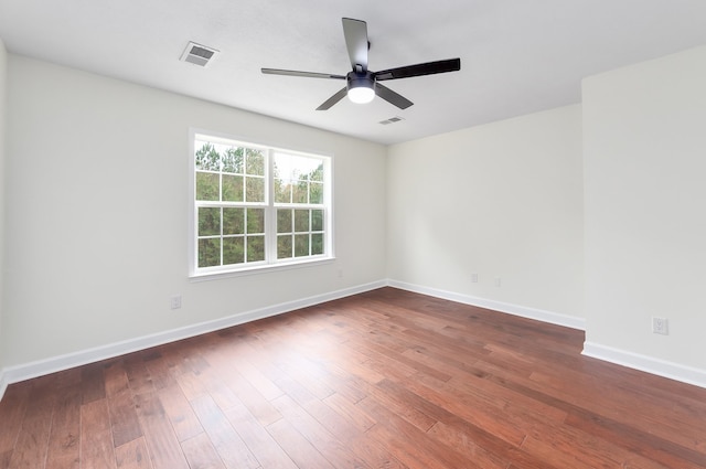 unfurnished room featuring dark wood-type flooring and ceiling fan