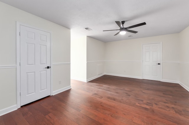 unfurnished room featuring dark wood-type flooring and ceiling fan